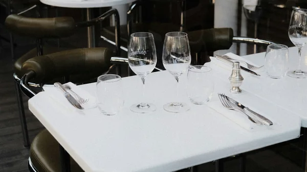 Taula de restaurant amb copes buides i coberts elegants.