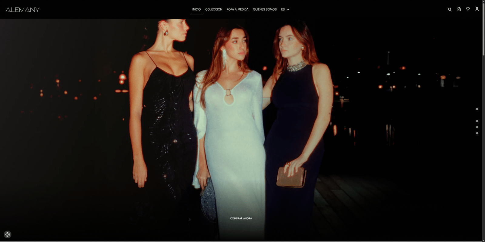 Tres mujeres con vestidos de noche exclusivos de Alemany Studio posan elegantemente bajo las luces de la ciudad.