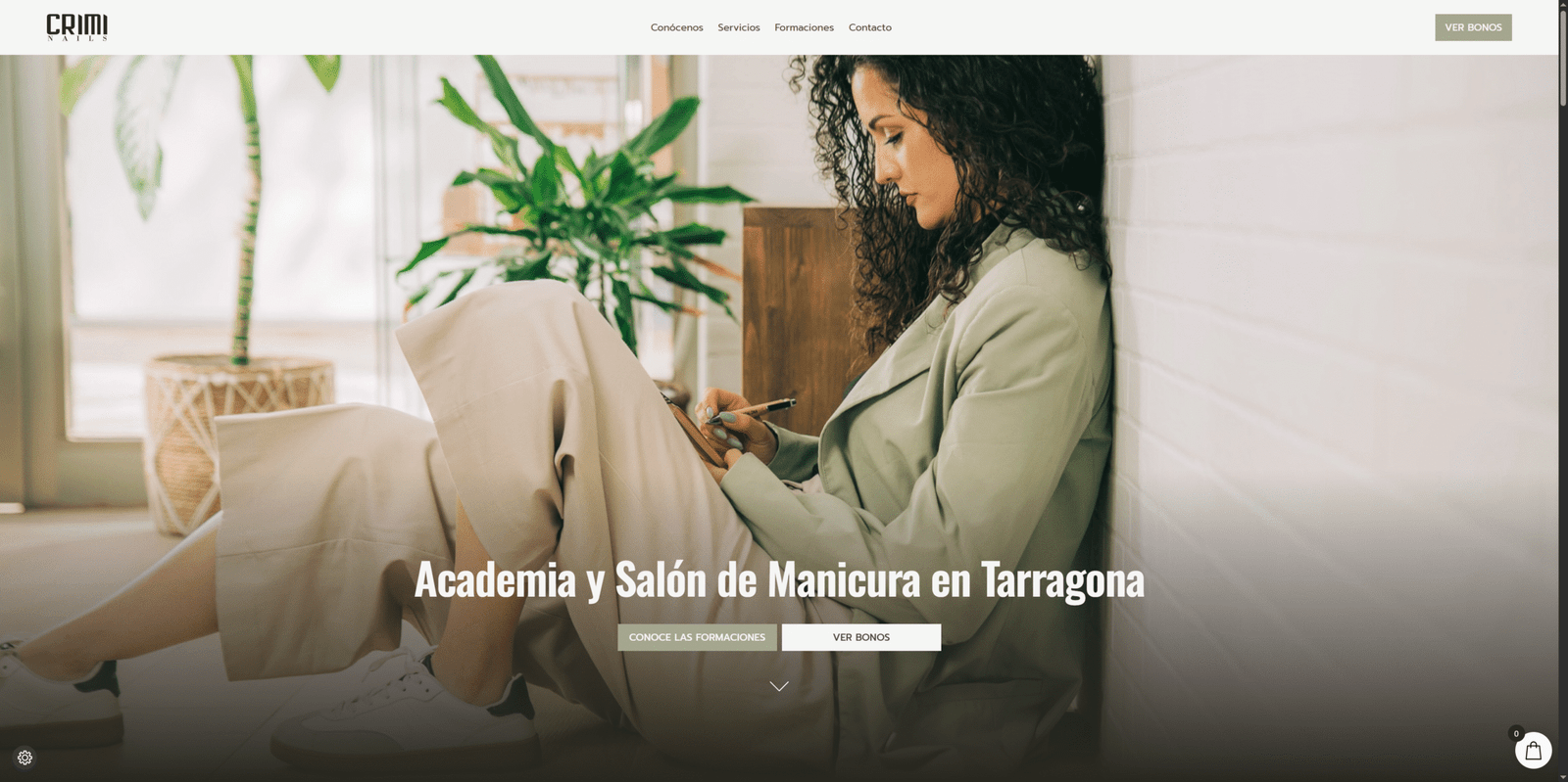 Mujer joven sentada en un salón moderno escribiendo en una libreta, representando la formación profesional en manicura de CrimiNails en Tarragona.